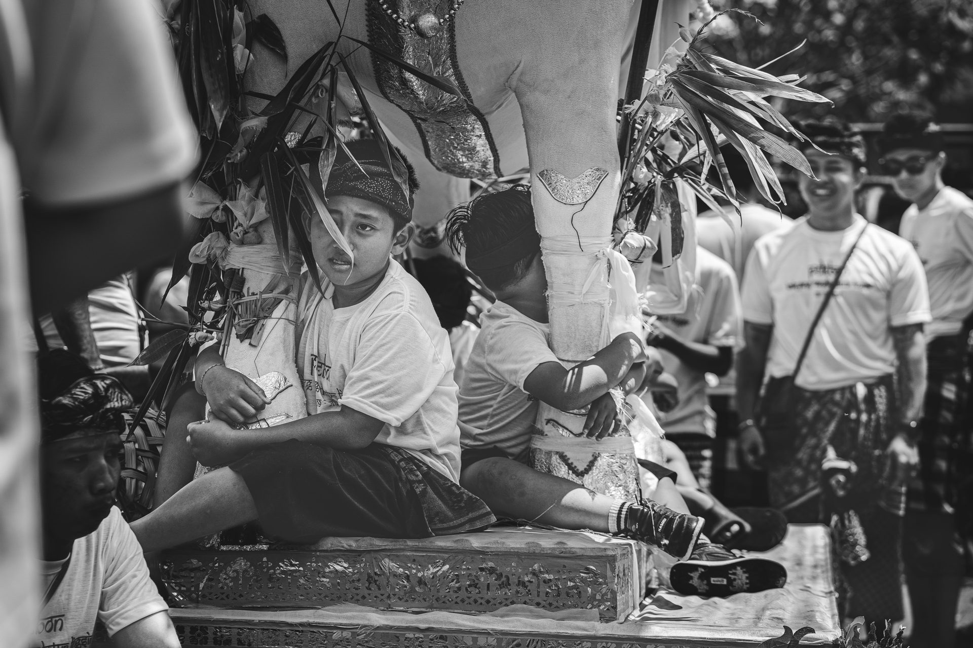 Enfants assis sur la plateforme du petulangan pendant la procession, Bali