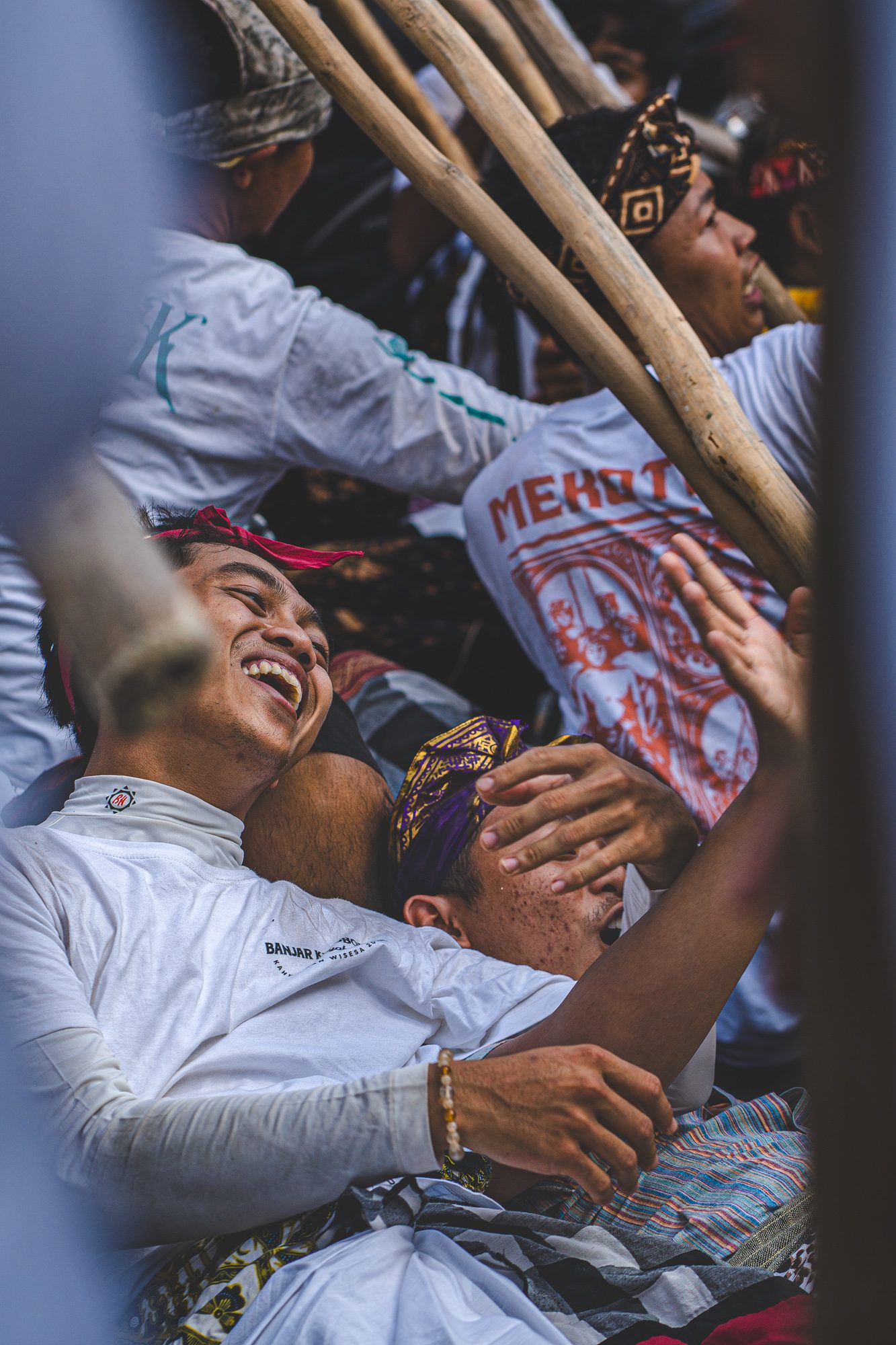 Groupe de jeunes hommes riant ensemble pendant le Mekotek, Munggu, Bali