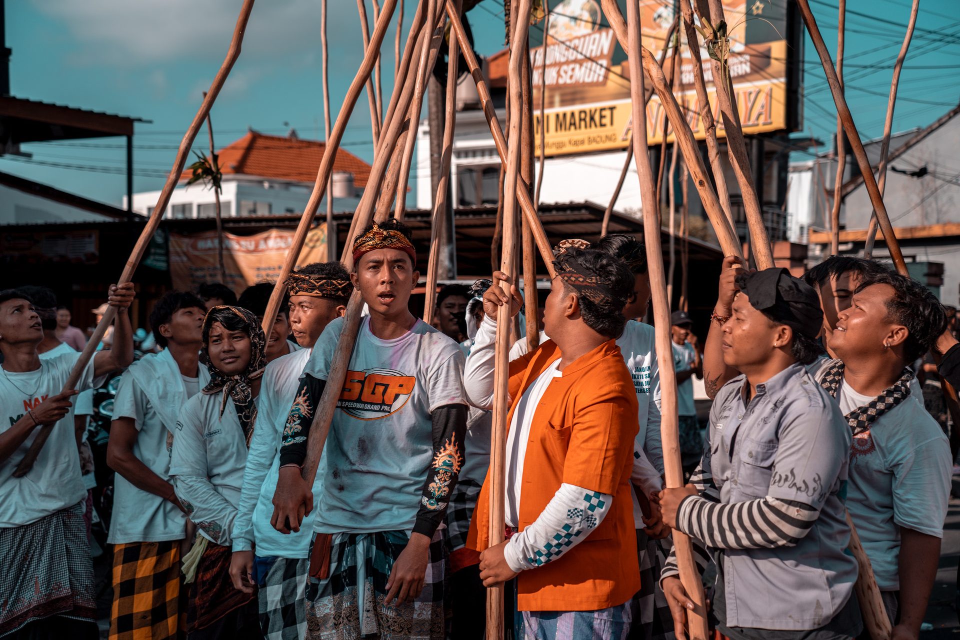 Groupe regardant vers le sommet de la pyramide de bâtons, Mekotek, Munggu, Bali